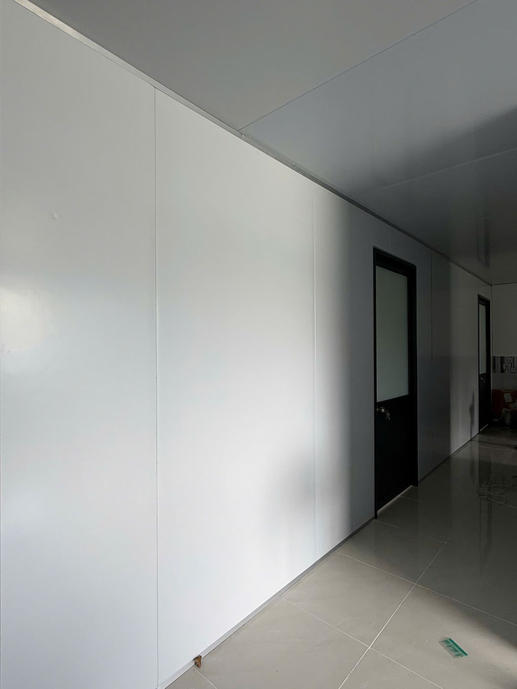 Hành lang vách Panel trắng với cửa đi kính mờ
